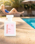 hideaway. Day Dream perfume 50ml bottle on a sunlit pool ledge on a summer afternoon