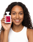 A smiling woman holding Hideaway. Apple Crush perfume