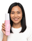 A smiling woman holding Hideaway. Black Essence body butter oil
