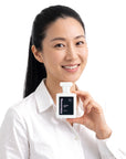 A smiling woman holding Hideaway. Cosmic Kiss perfume