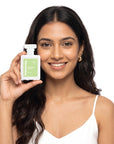 A smiling woman holding Hideaway. Kiwi Berry Bang perfume
