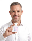 A smiling man holding Hideaway. Love Drunk perfume