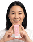 A smiling woman holding Hideaway. Aurora Rouge mini body custard