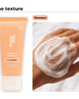 Shampoo texture lathered on a hand, beside Hideaway. Black Essence mini shampoo