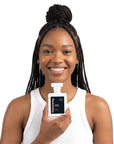 A smiling woman holding Hideaway. Sweet Chaos perfume