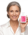 A smiling woman holding Hideaway. Sweet Heart perfume