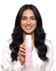 A smiling woman holding Hideaway. Vanilla Delight body butter oil