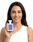 A smiling woman holding Hideaway. Velvet Affair perfume