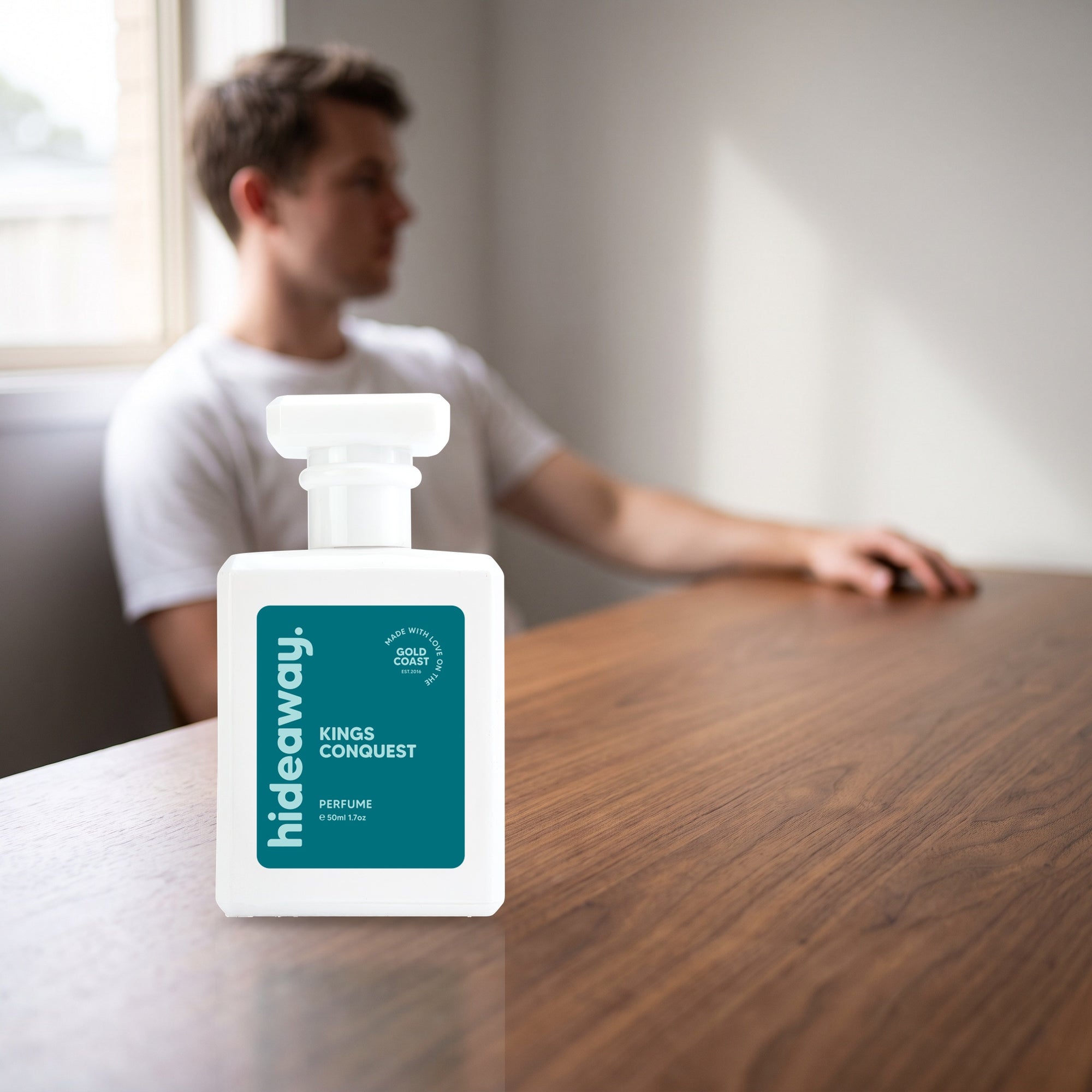hideaway. Kings Conquest perfume 50ml bottle on a walnut desk in warm daylight
