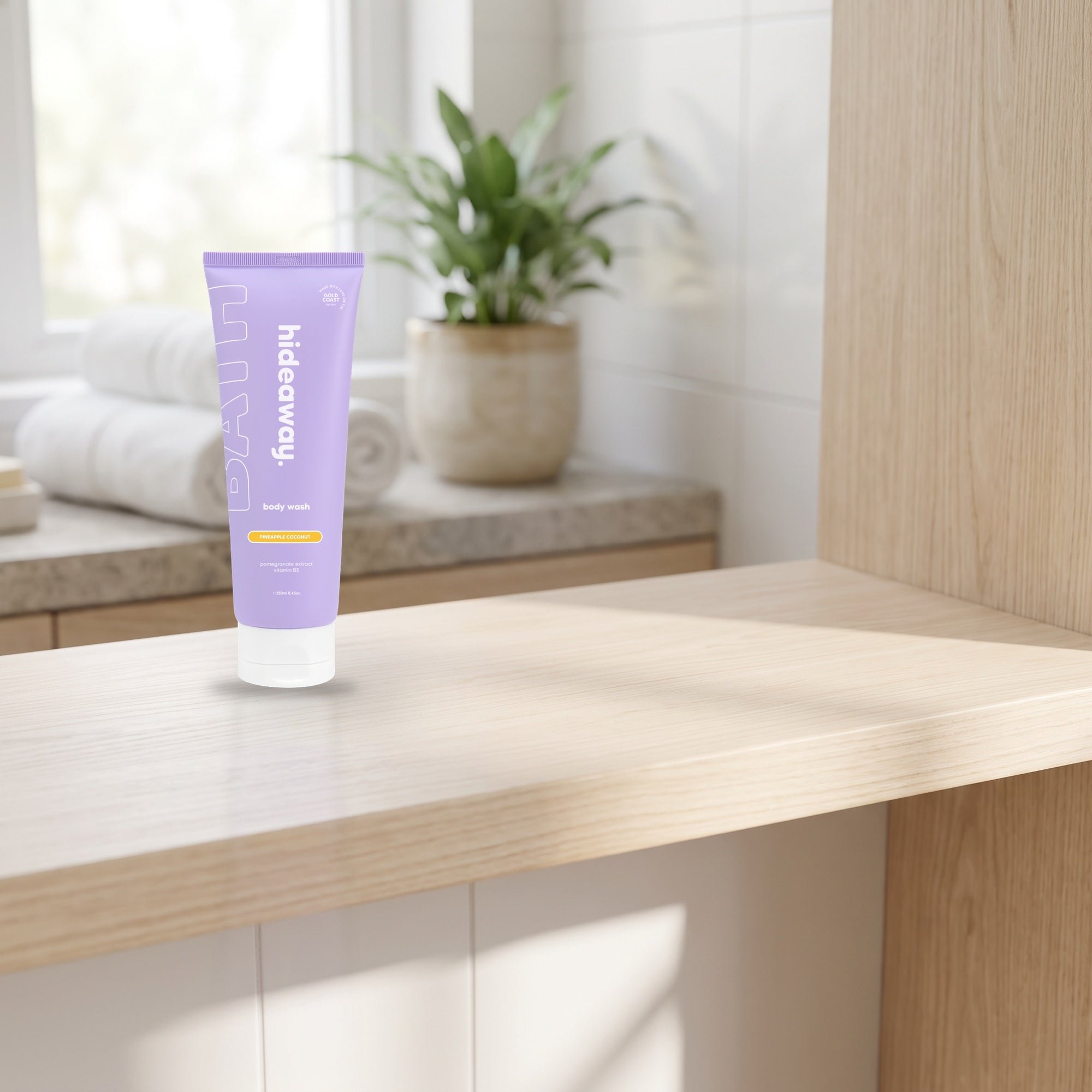 hideaway. Pineapple Coconut Body Wash on a timber bathroom shelf beside rolled towels