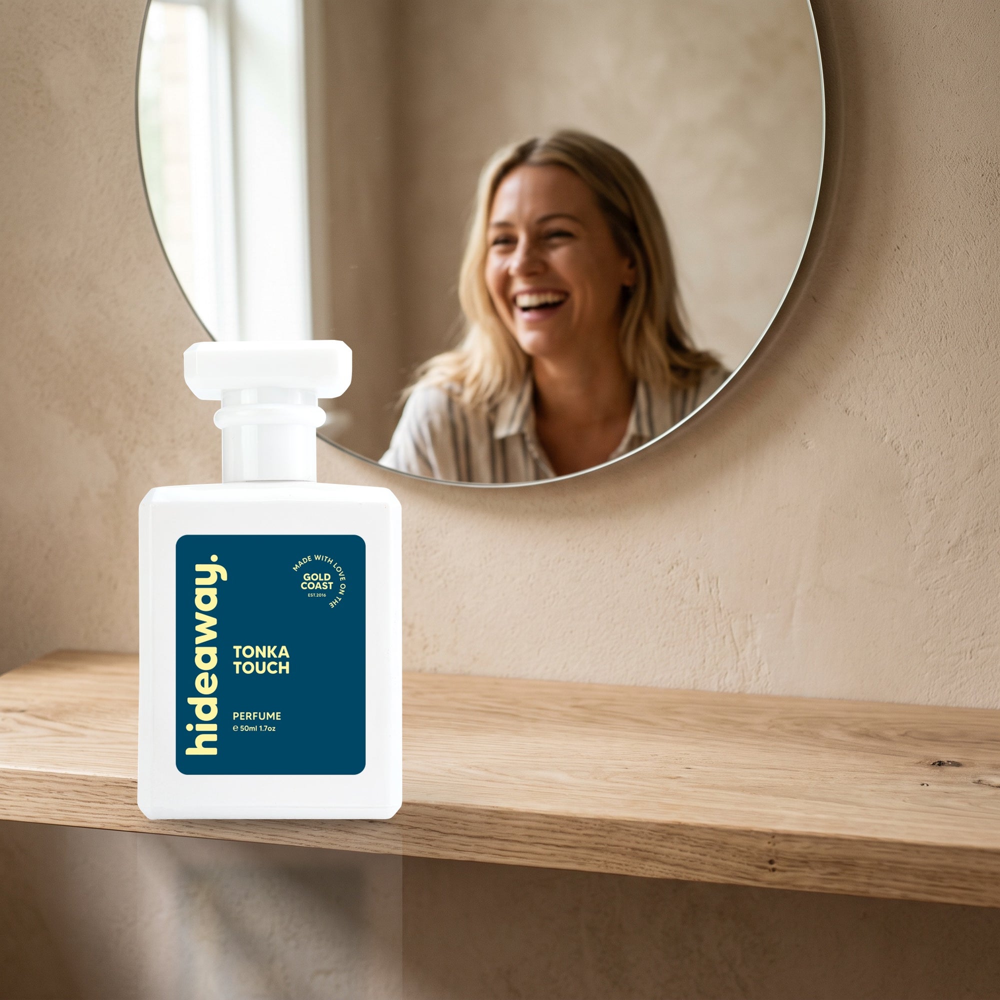 hideaway. Tonka Touch perfume 50ml bottle on an oak shelf below a round mirror