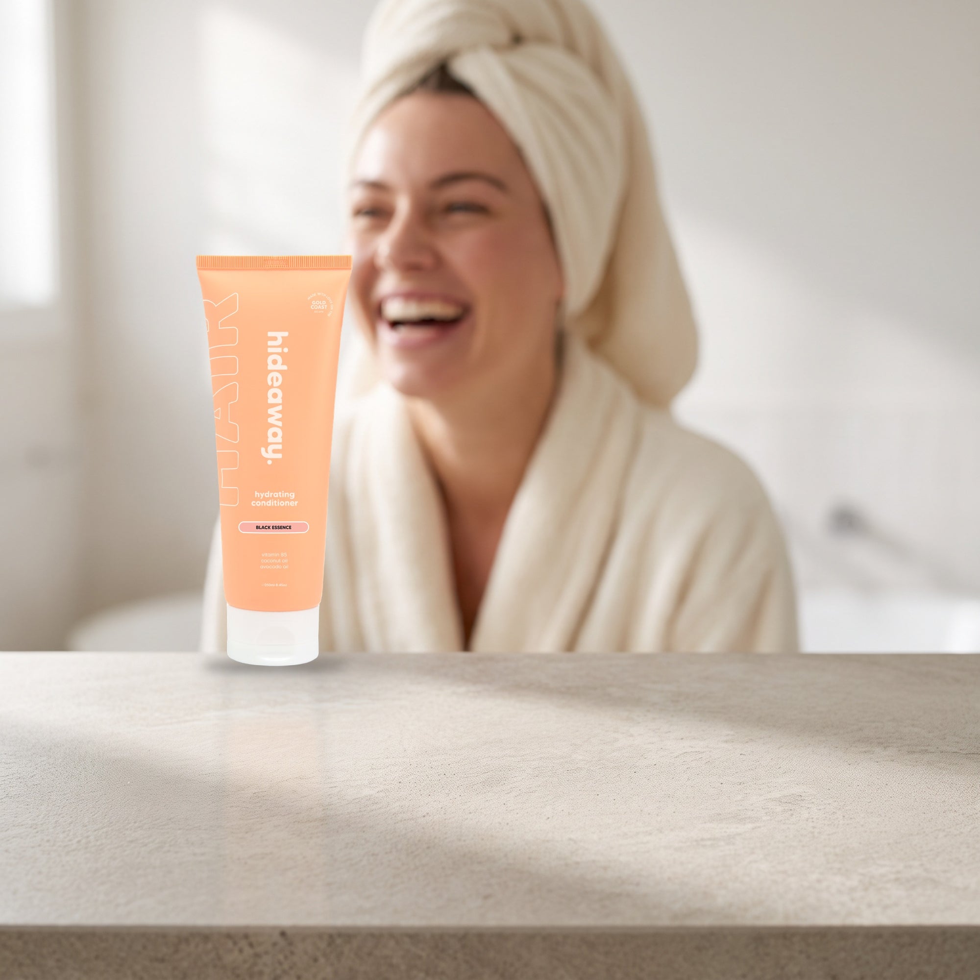 hideaway. Black Essence Conditioner on a white shelf in a bright tiled bathroom
