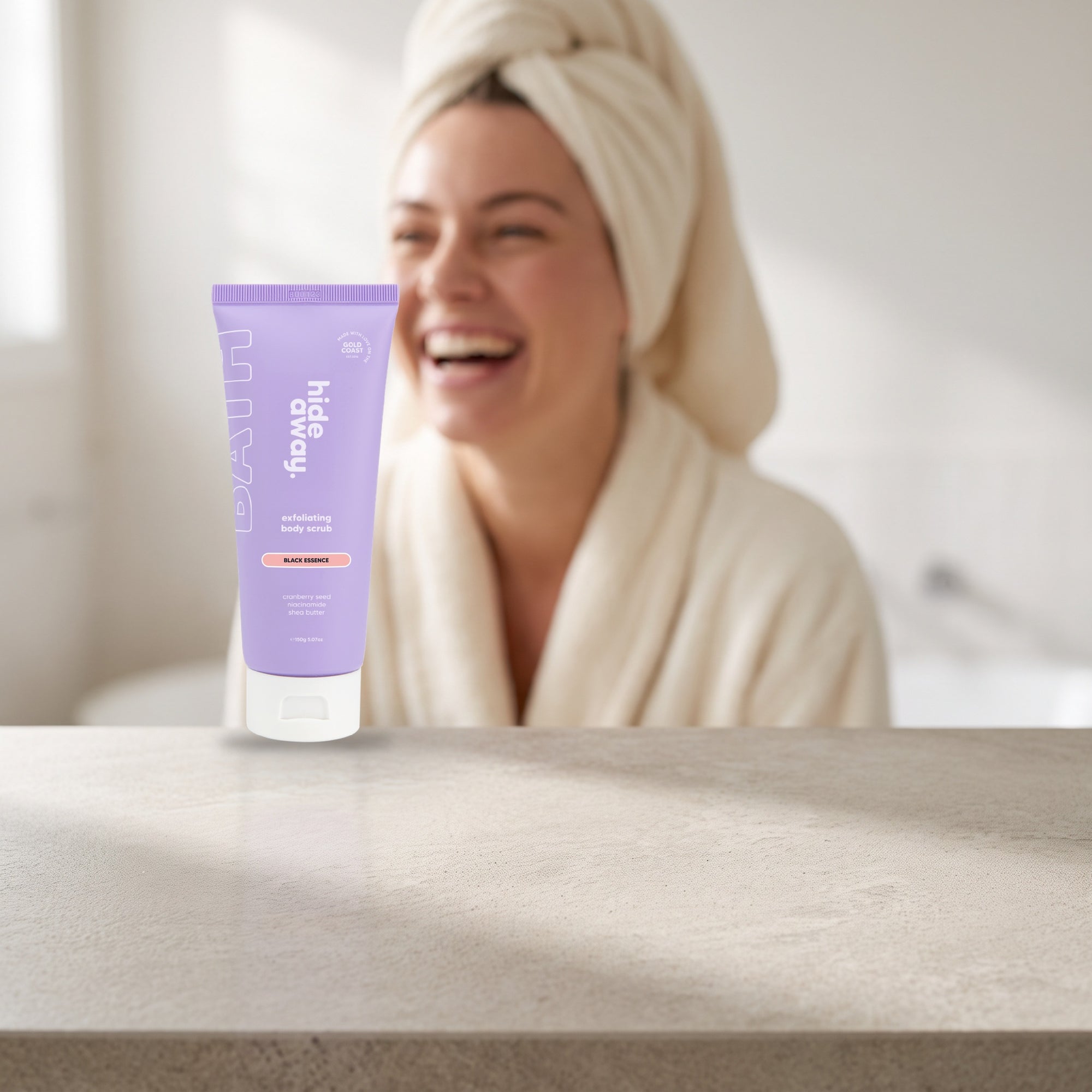 hideaway. Mini Black Essence Body Scrub on a stone bathroom counter in soft daylight
