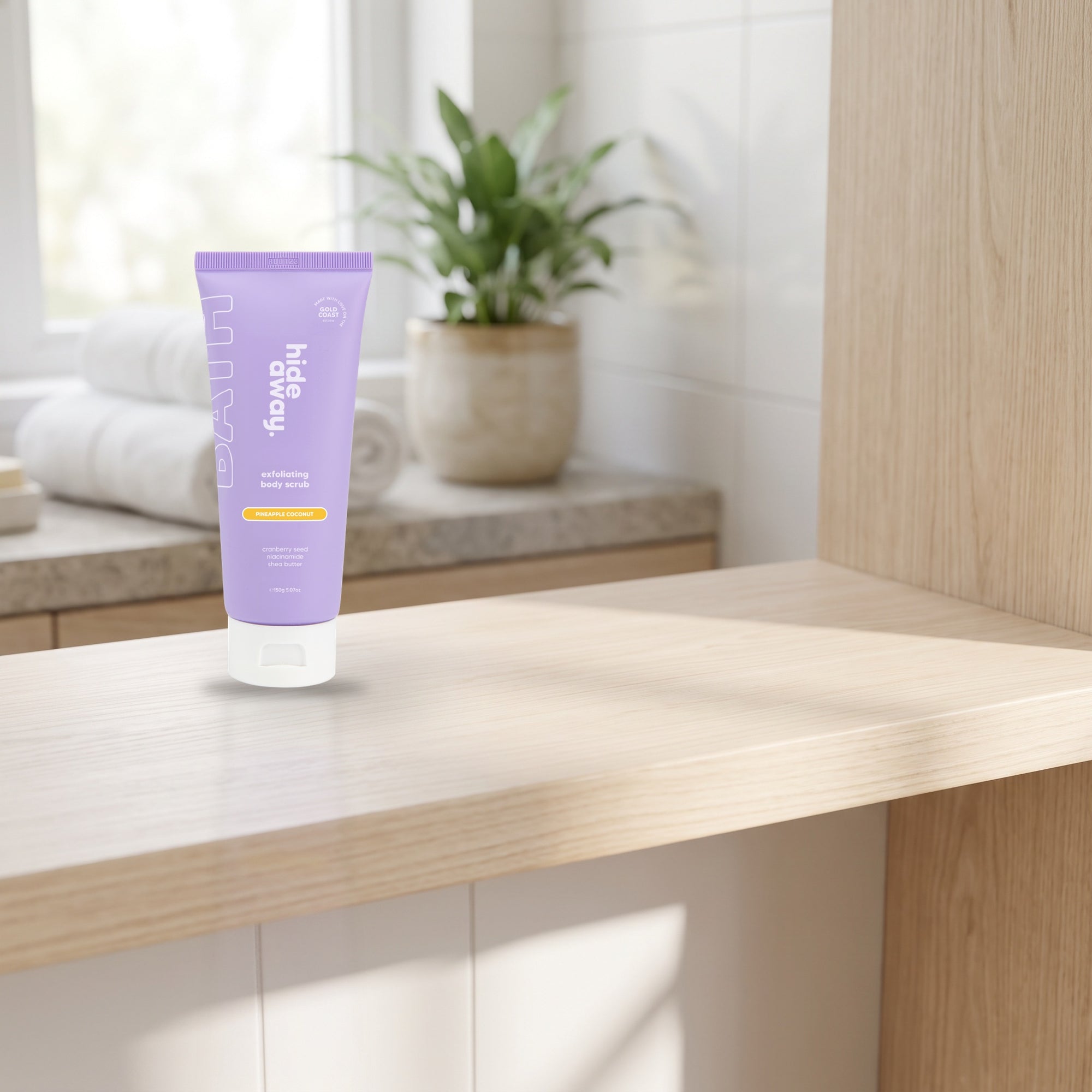 hideaway. Pineapple Coconut Body Scrub on a timber bathroom shelf beside rolled towels