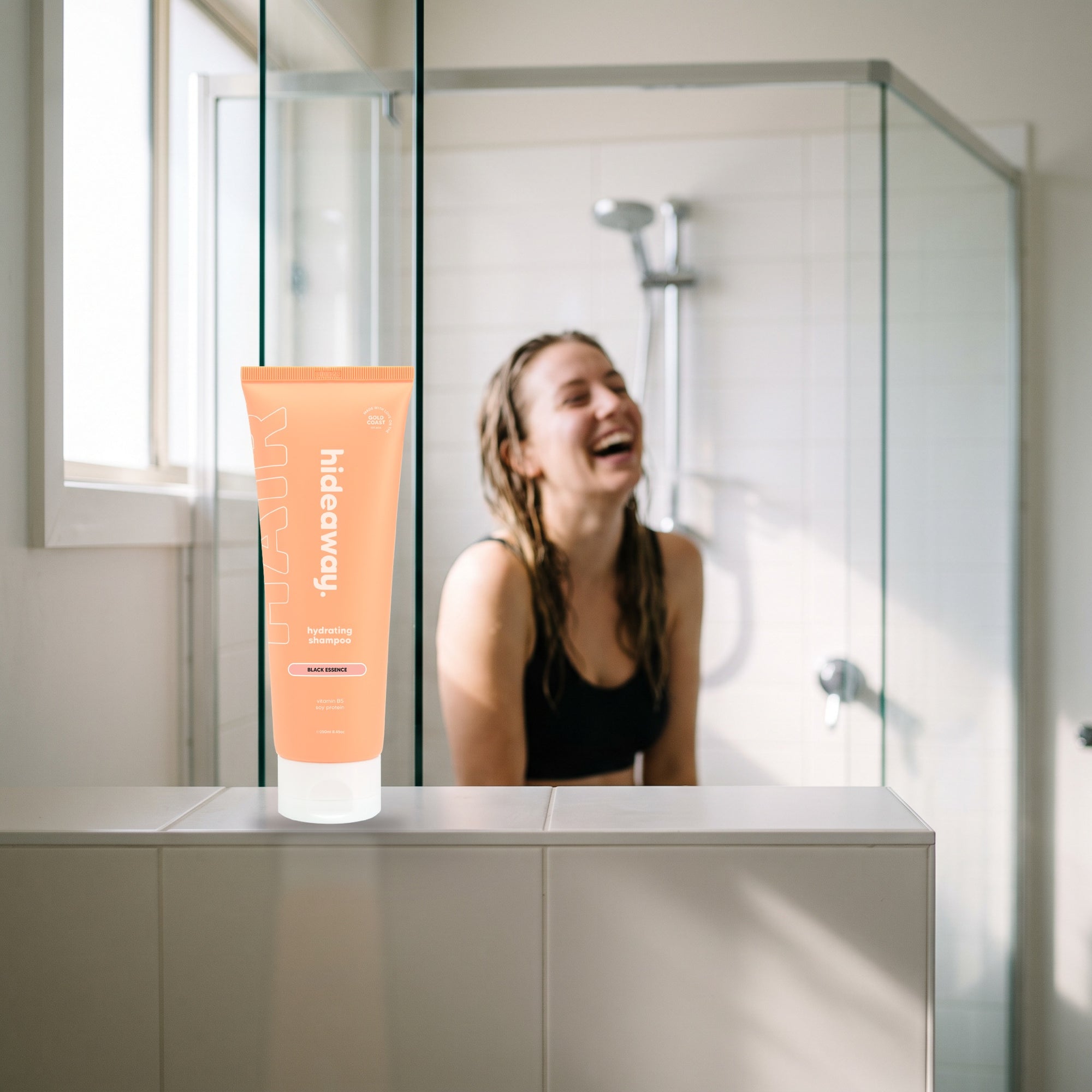 hideaway. Black Essence Shampoo on a shower ledge in a bright bathroom