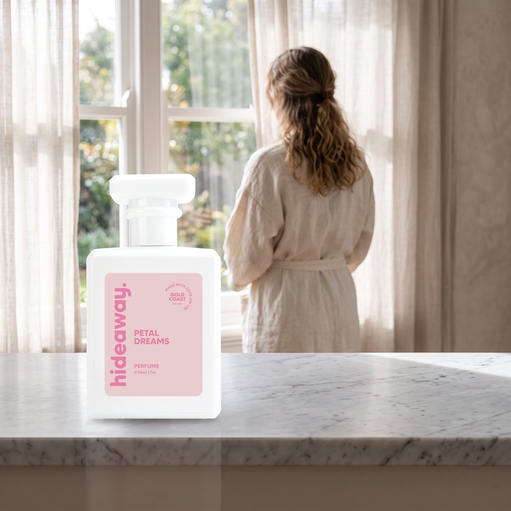hideaway. Petal Dreams perfume 50ml bottle on a marble ledge by a sunlit window
