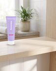 hideaway. Mini Aurora Rouge Body Wash on a timber bathroom shelf beside rolled towels