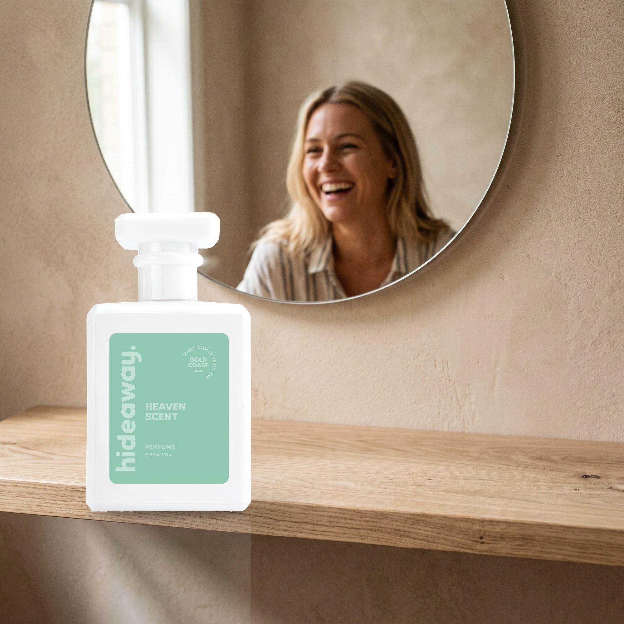 hideaway. Heaven Scent perfume 50ml bottle on an oak shelf below a round mirror