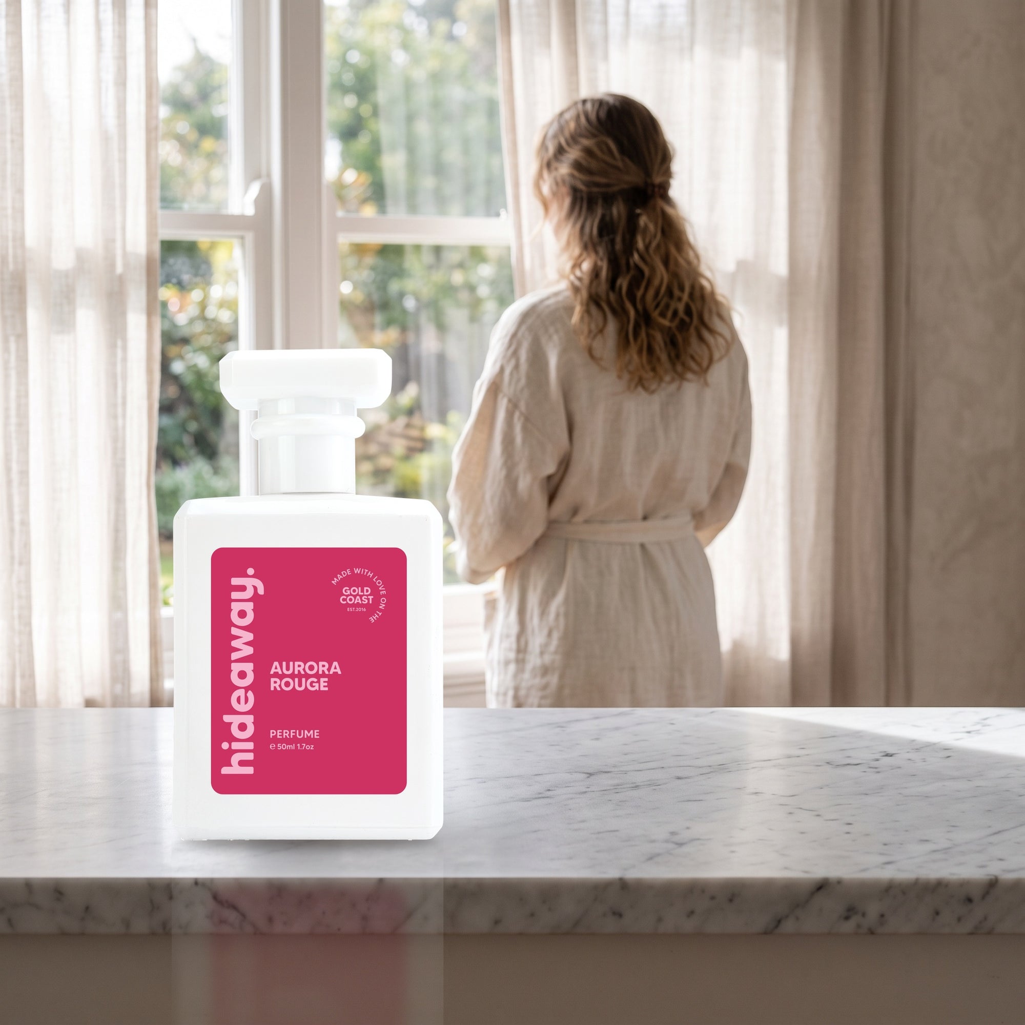 hideaway. Aurora Rouge perfume 50ml bottle on a marble ledge by a sunlit window