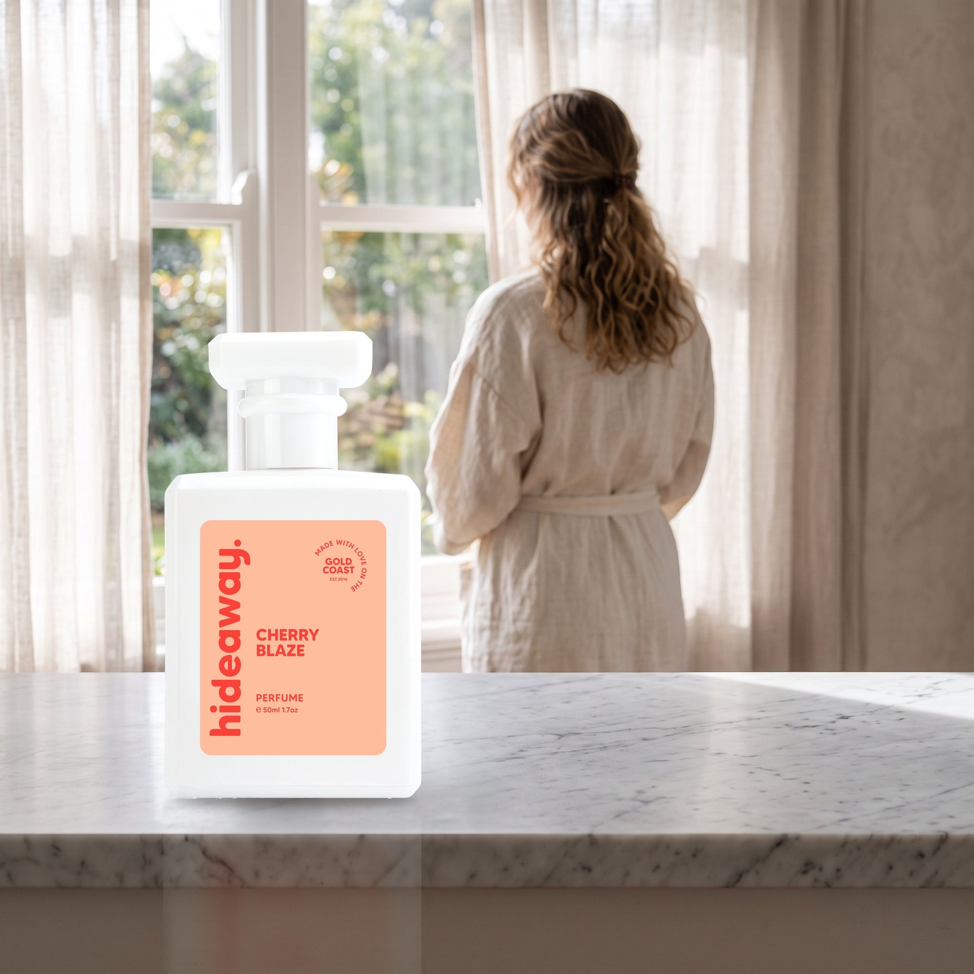 hideaway. Cherry Blaze perfume 50ml bottle on a marble ledge by a sunlit window