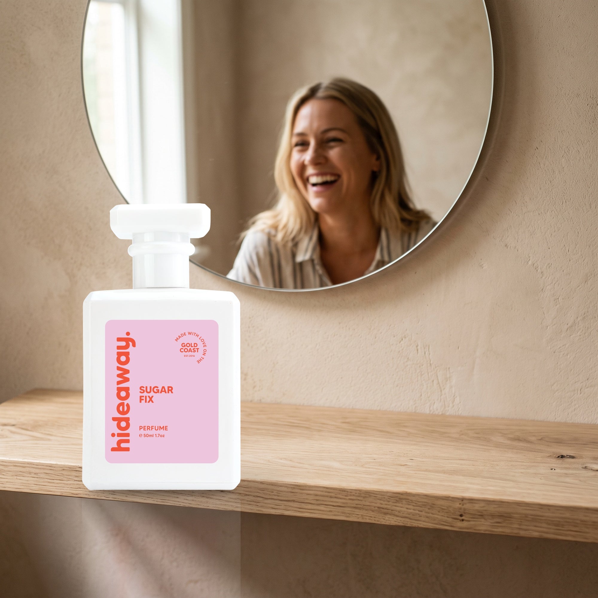 hideaway. Sugar Fix perfume 50ml bottle on an oak shelf below a round mirror