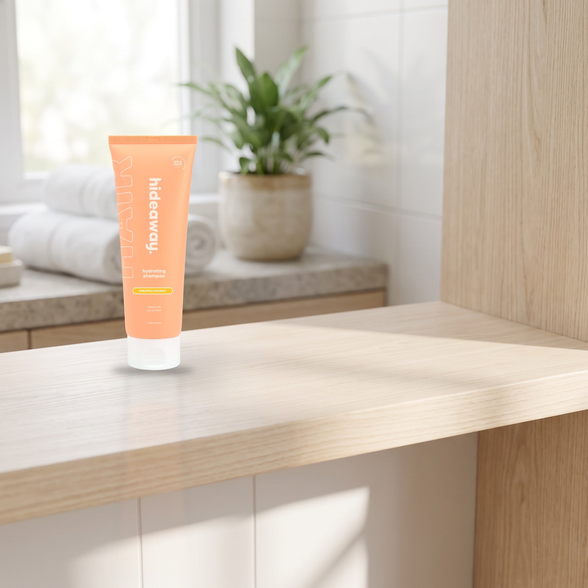 hideaway. Pineapple Coconut Shampoo on a timber bathroom shelf beside rolled towels