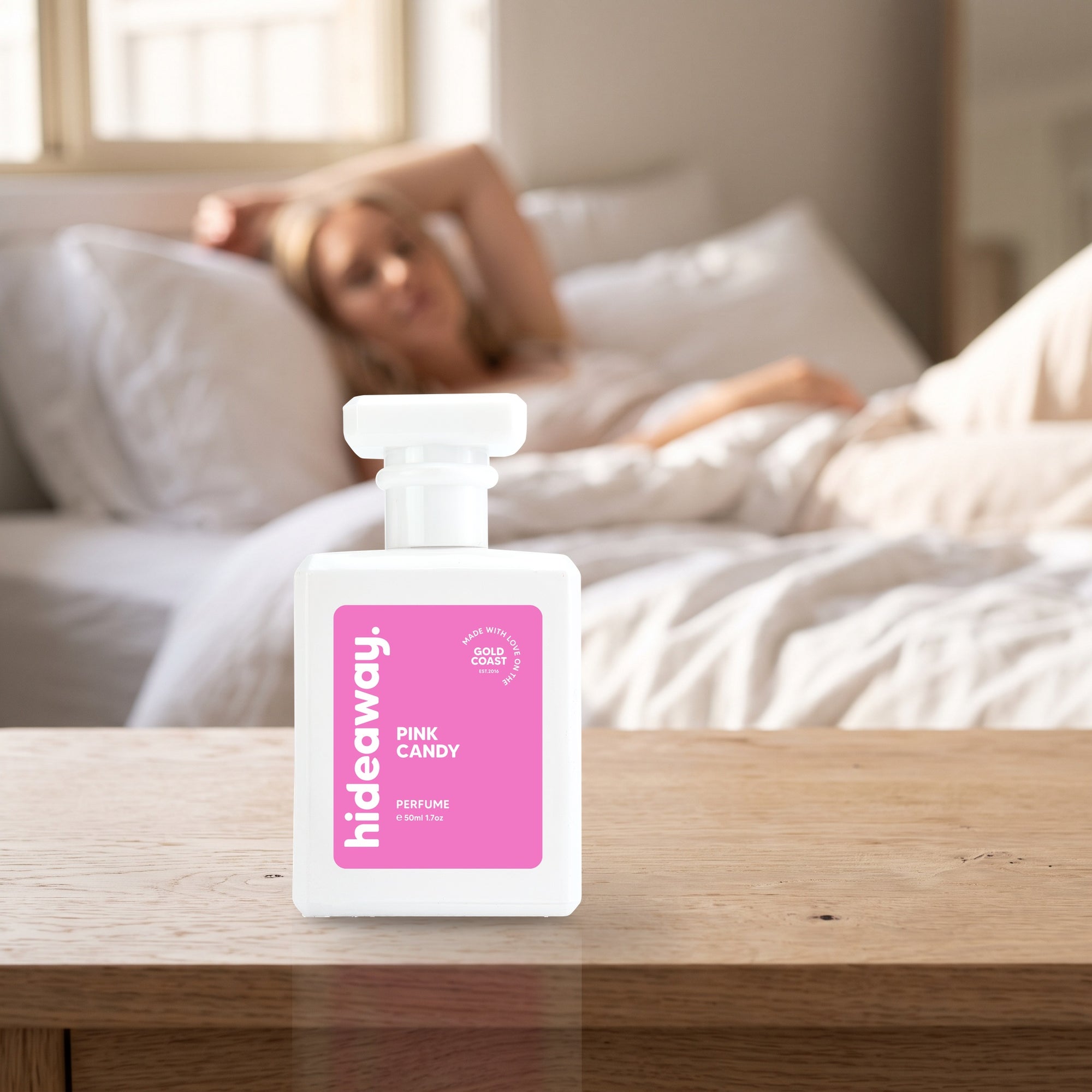 hideaway. Pink Candy perfume 50ml bottle on a bedside table in warm morning light