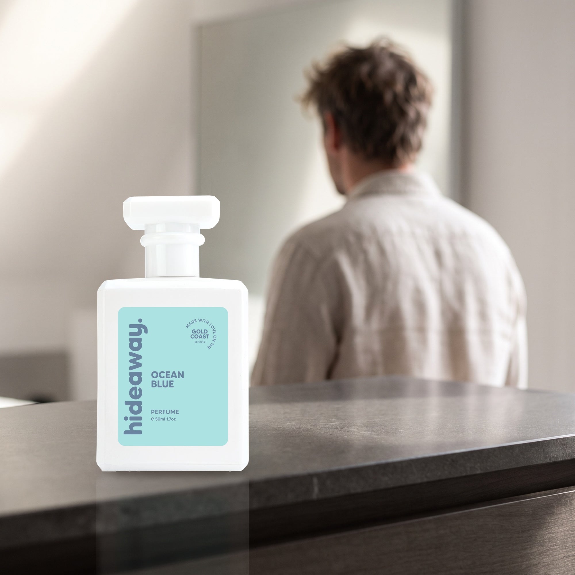 hideaway. Ocean Blue perfume 50ml bottle on a stone dresser in soft morning light