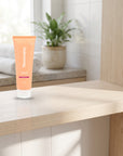 hideaway. Mini Aurora Rouge Conditioner on a timber bathroom shelf beside rolled towels