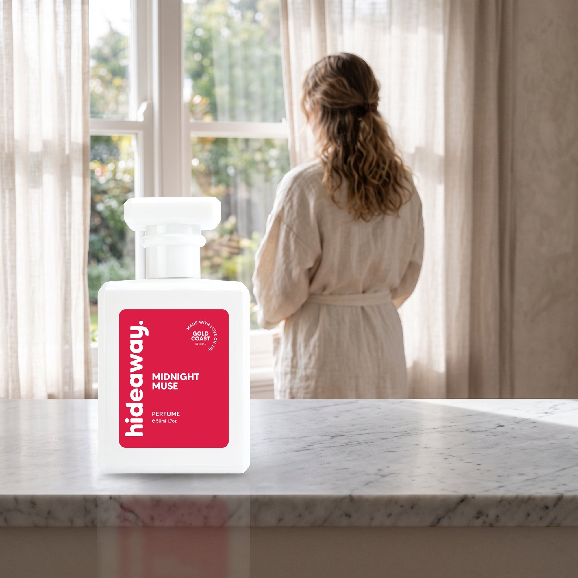 hideaway. Midnight Muse perfume 50ml bottle on a marble ledge by a sunlit window
