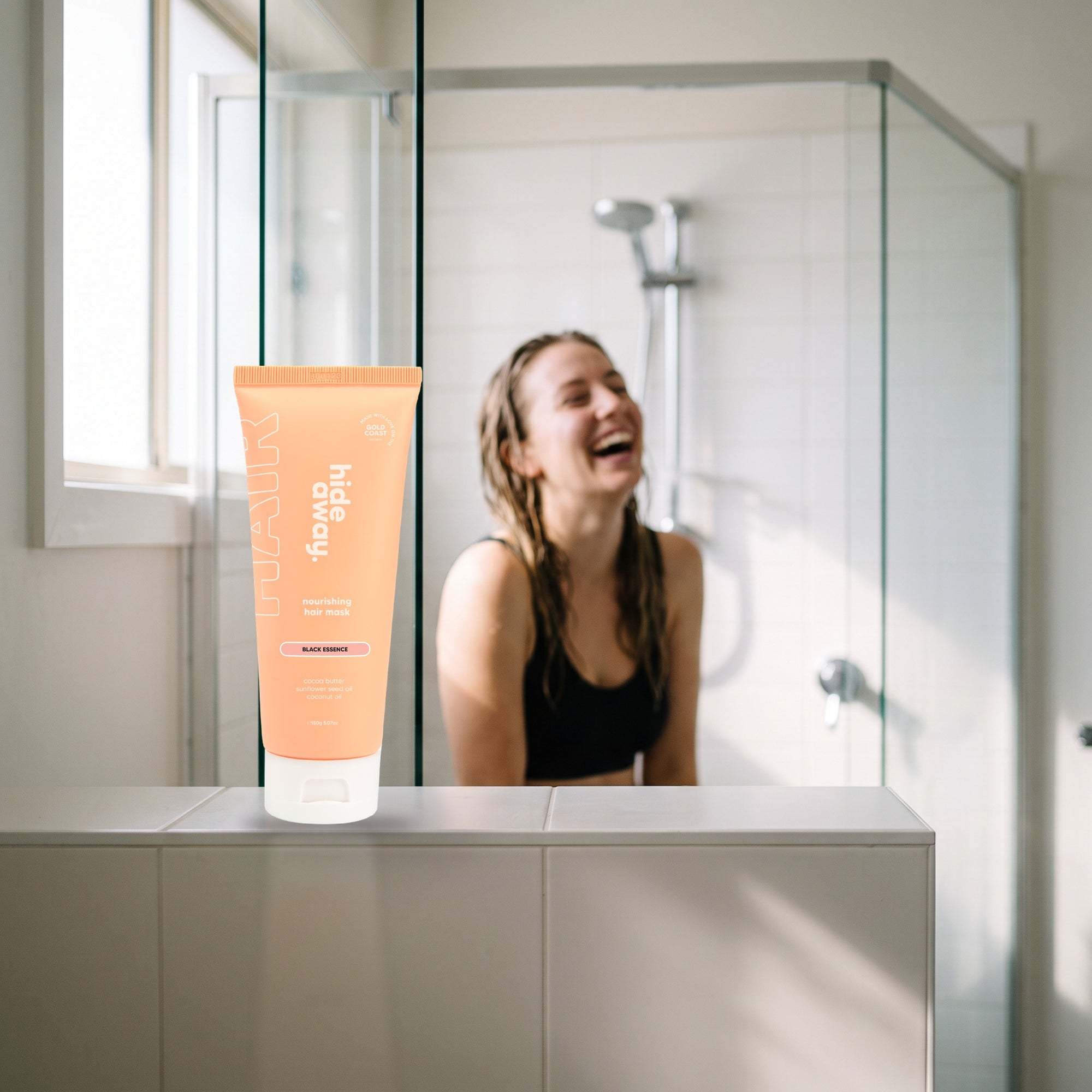 hideaway. Black Essence Hair Mask on a shower ledge in a bright bathroom