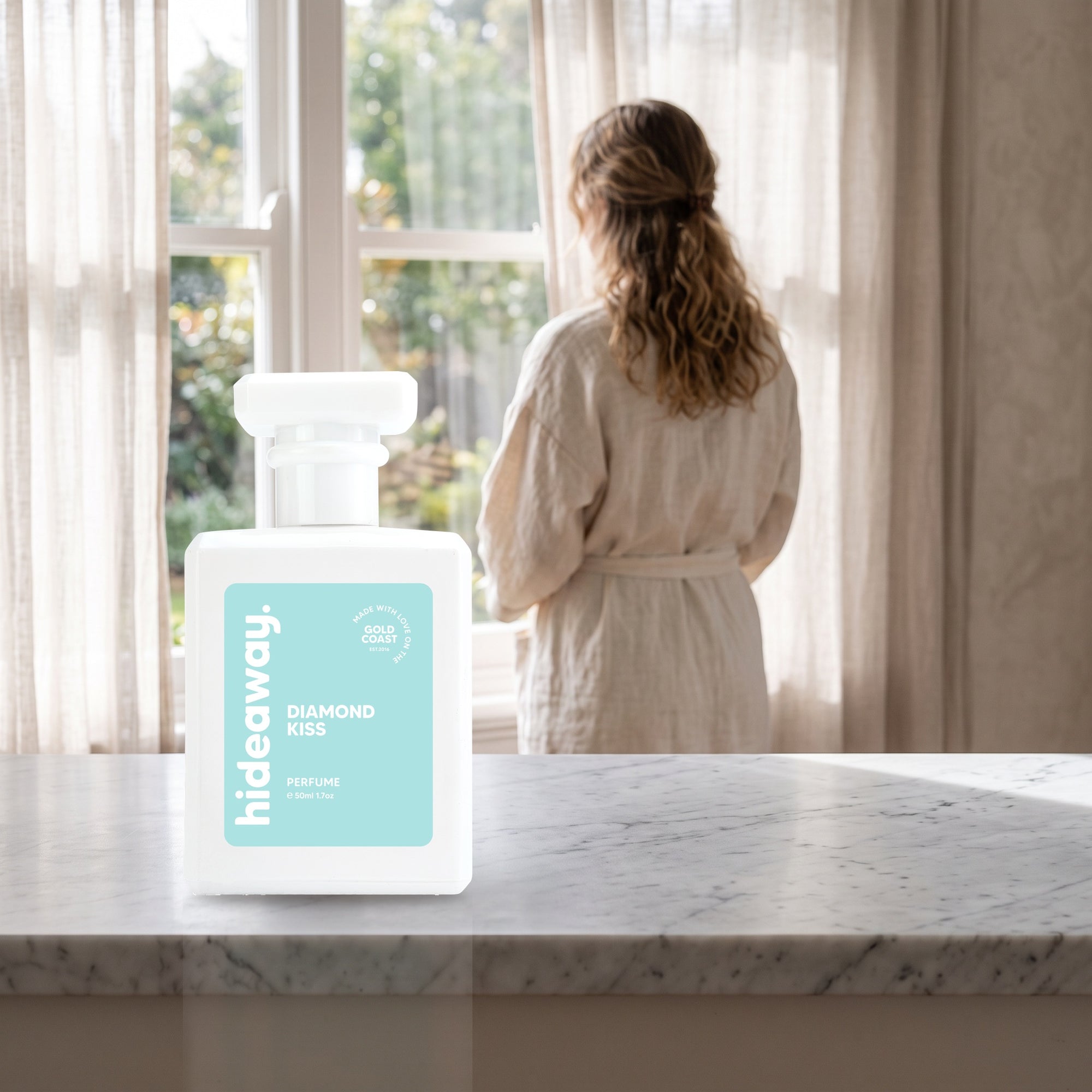 hideaway. Diamond Kiss perfume 50ml bottle on a marble ledge by a sunlit window