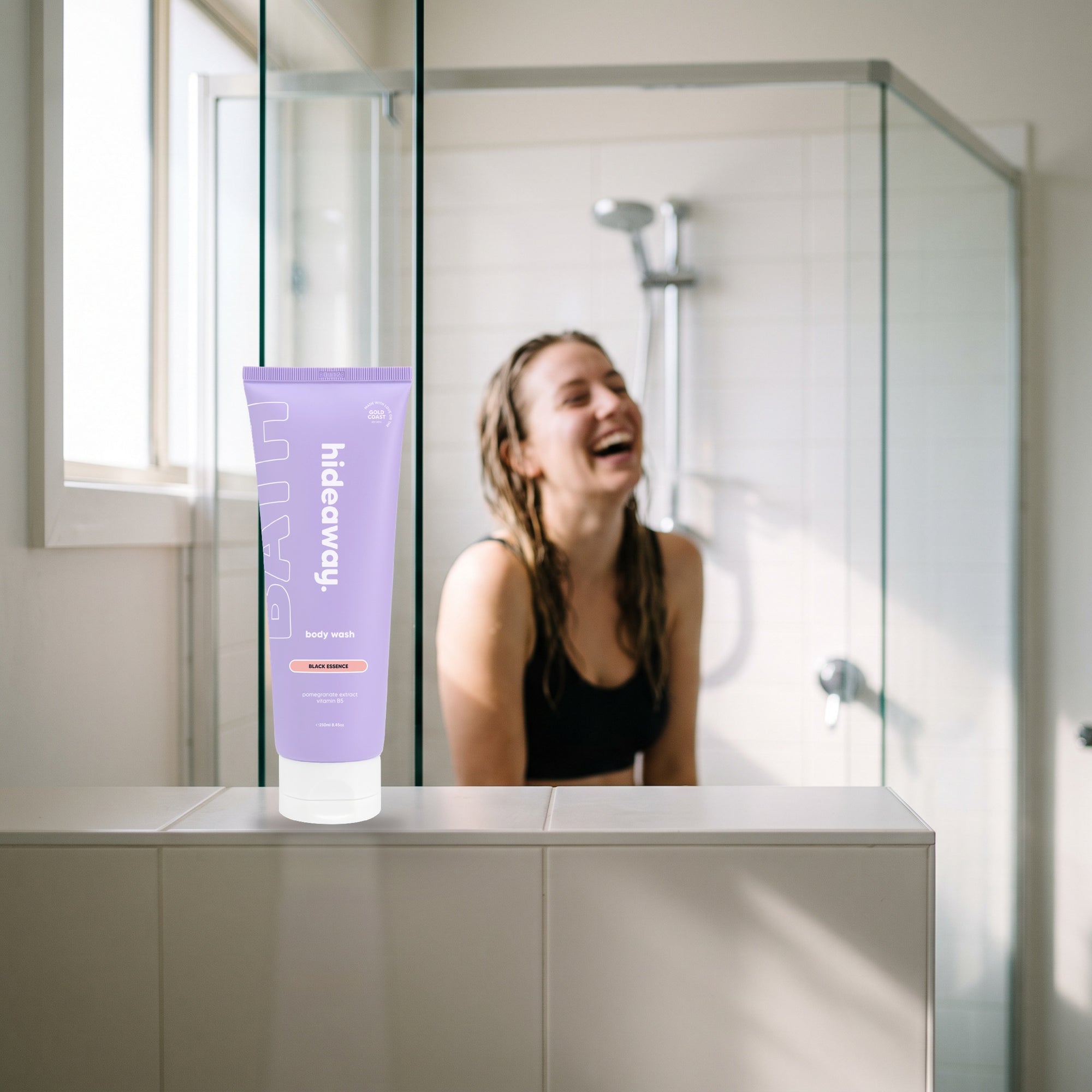 hideaway. Mini Black Essence Body Wash on a shower ledge in a bright bathroom