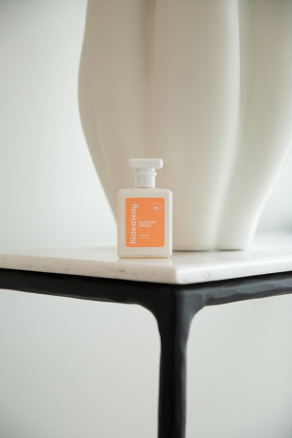 A hideaway. perfume standing upright on a marble side table