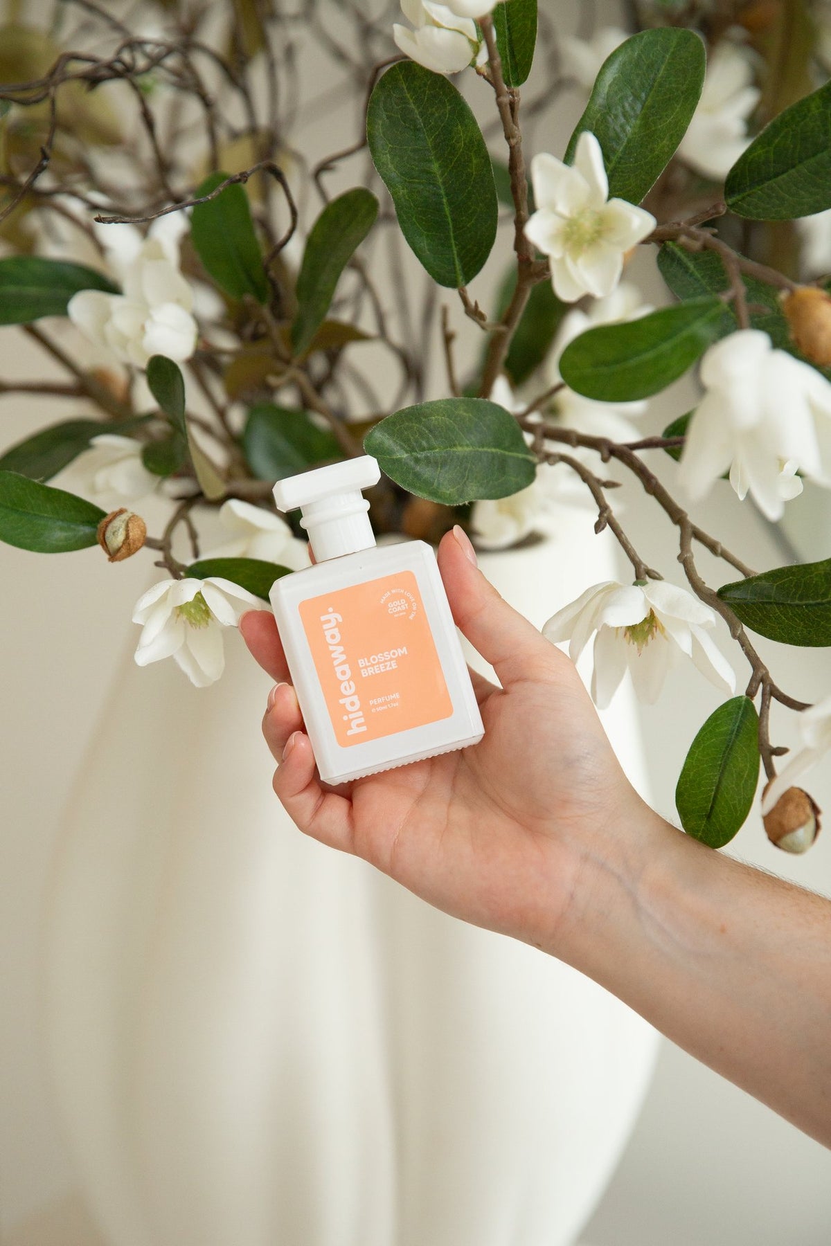Holding a hideaway. perfume among magnolia flowers