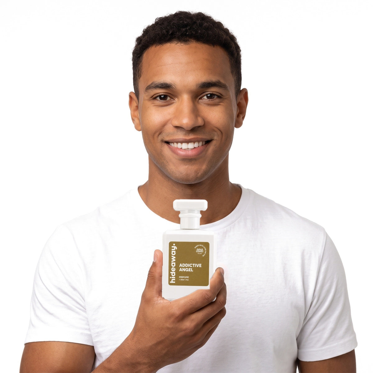 A smiling man holding Hideaway. Addictive Angel perfume
