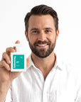 A smiling man holding Hideaway. Aqua Noir perfume