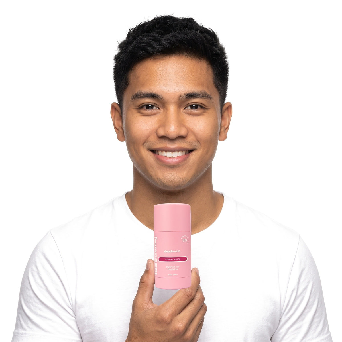 A smiling man holding Hideaway. Aurora Rouge deodorant