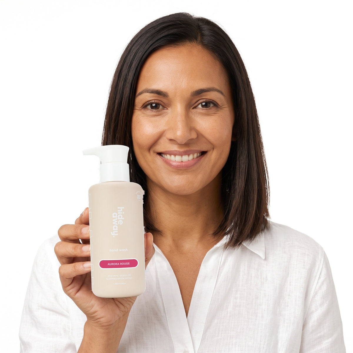 A smiling woman holding Hideaway. Aurora Rouge hand wash