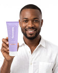 A smiling man holding Hideaway. Black Essence body wash