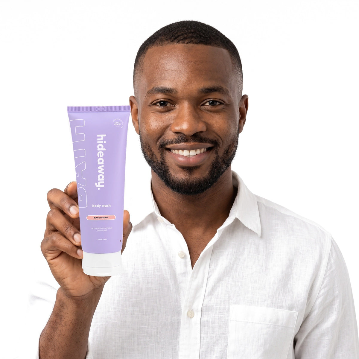 A smiling man holding Hideaway. Black Essence body wash