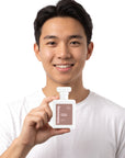 A smiling man holding Hideaway. Boheme Whisper perfume