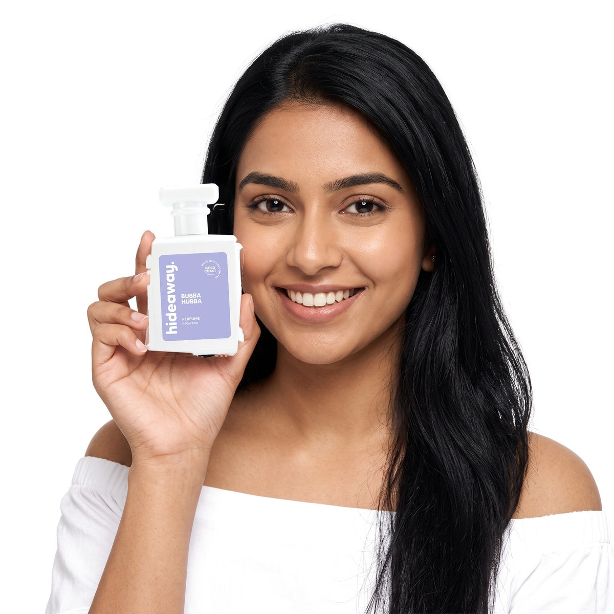 A smiling woman holding Hideaway. Bubba Hubba perfume