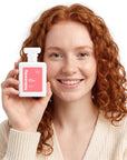 A smiling woman holding Hideaway. Chic Allure perfume