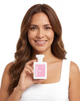 A smiling woman holding Hideaway. Flower Power perfume