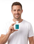 A smiling man holding Hideaway. Kings Conquest perfume