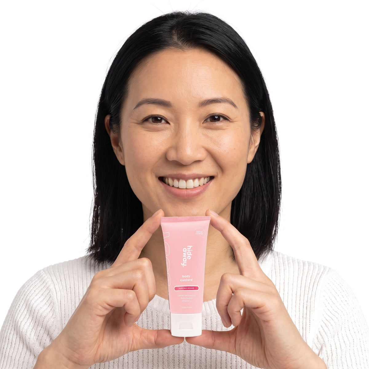 A smiling woman holding Hideaway. Aurora Rouge mini body custard