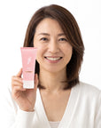 A smiling woman holding Hideaway. Black Essence mini body custard