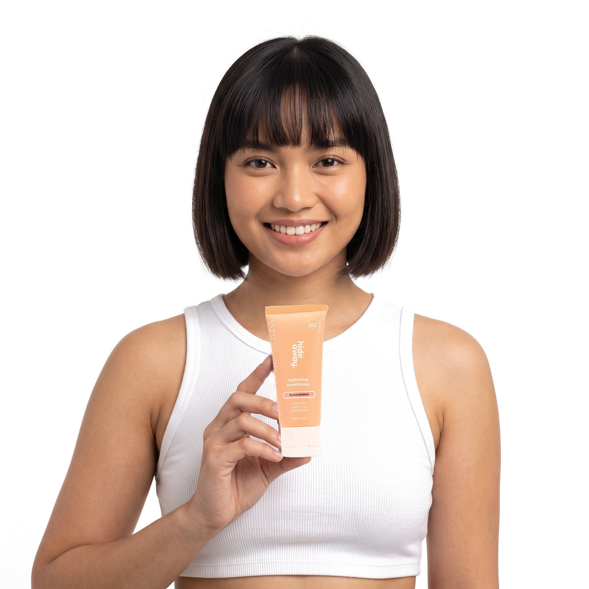 A smiling woman holding Hideaway. Black Essence mini conditioner