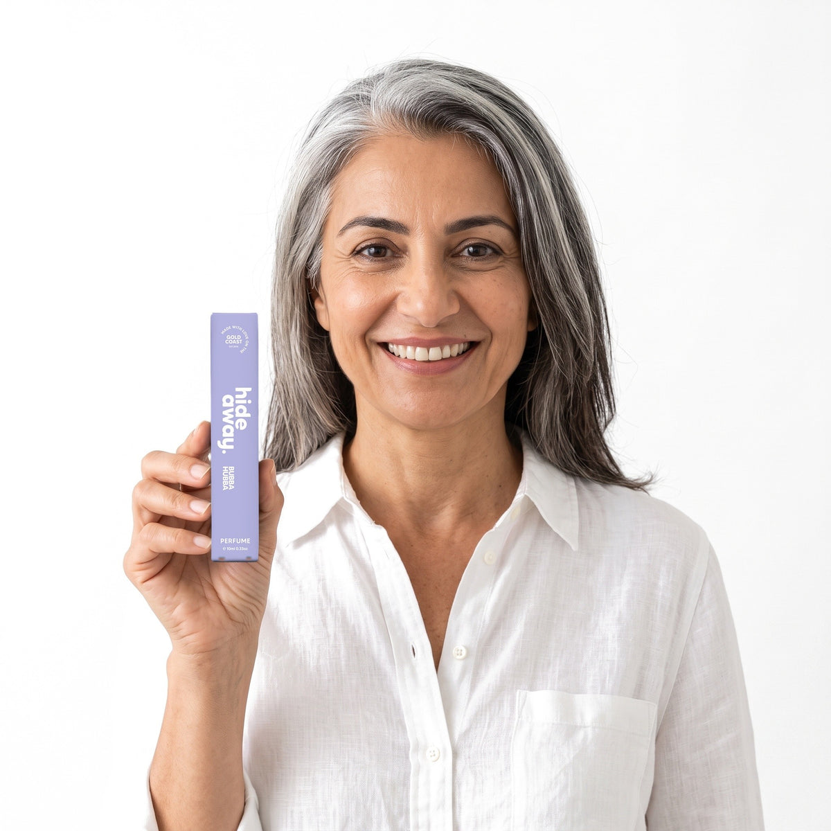 A smiling woman holding the Hideaway. Bubba Hubba 10ml perfume box